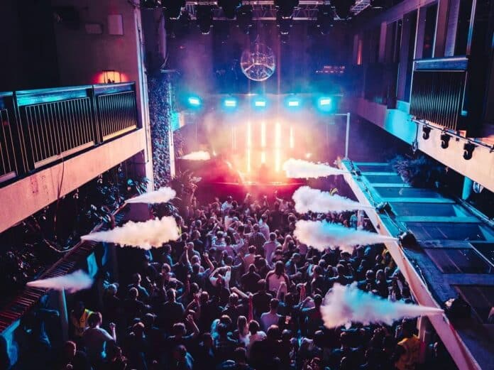 Crowded UK nightclub with colorful lights