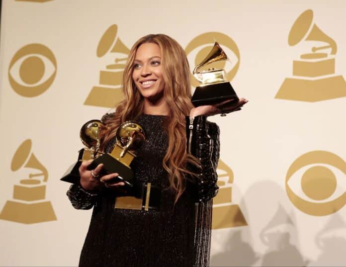 Person holding multiple Grammy trophies