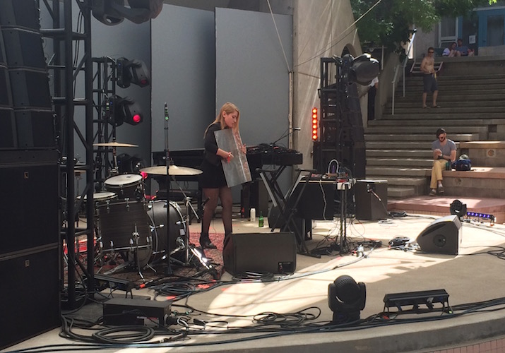 Woman holds sheet metal on stage