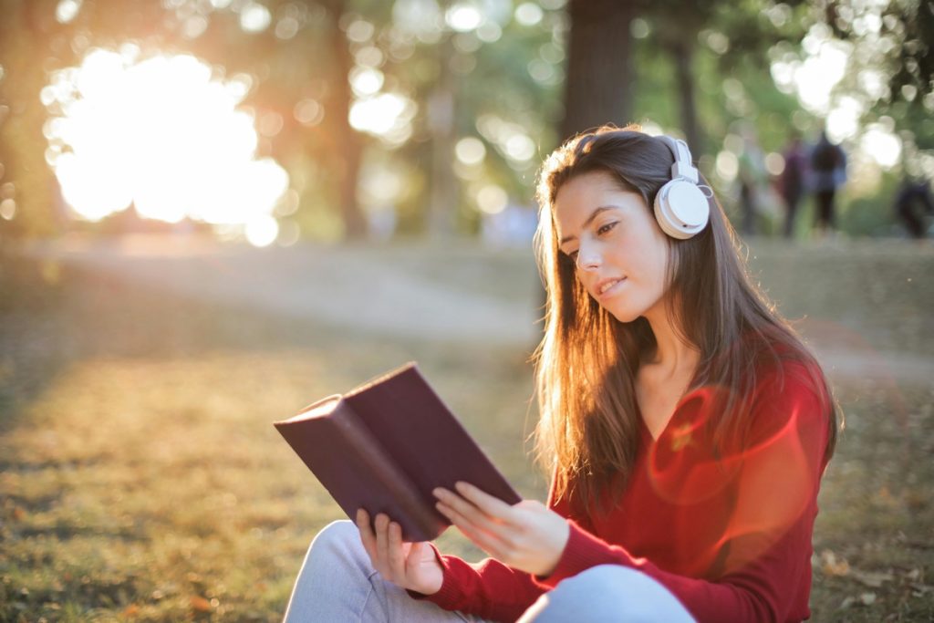 Woman reading while wearing headphones