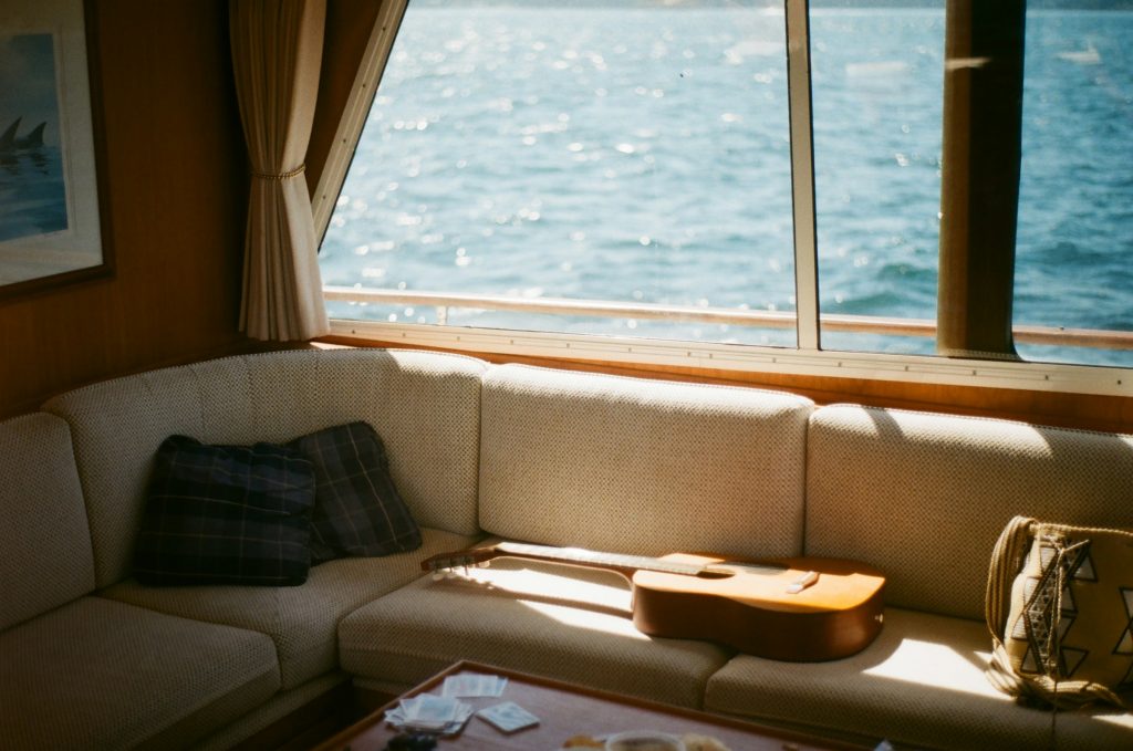 Acoustic guitar resting on seaside couch