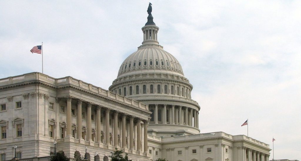 US Capitol with flags at sunset