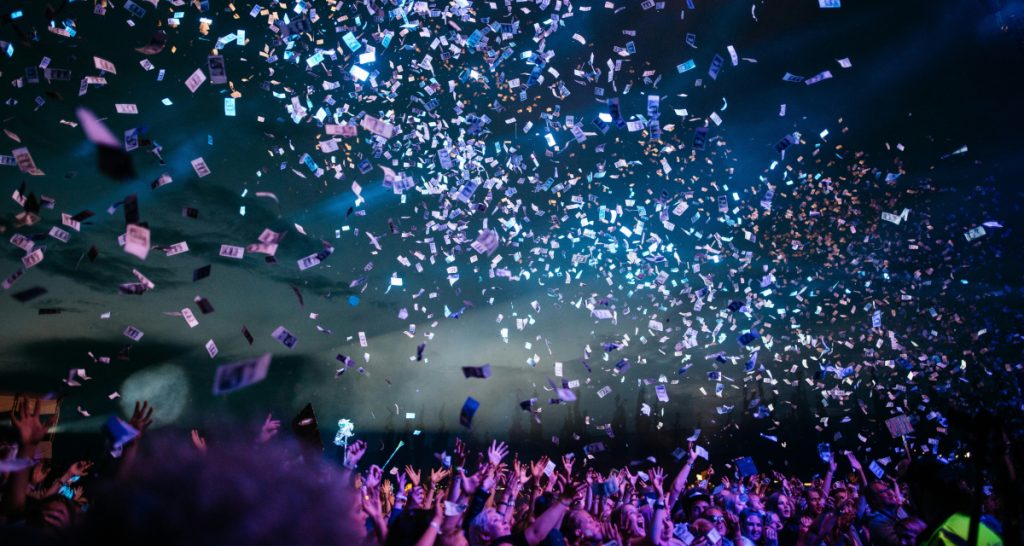 People throwing money at concert crowd