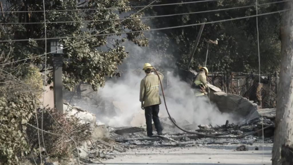 Firefighters inspecting wildfire damage