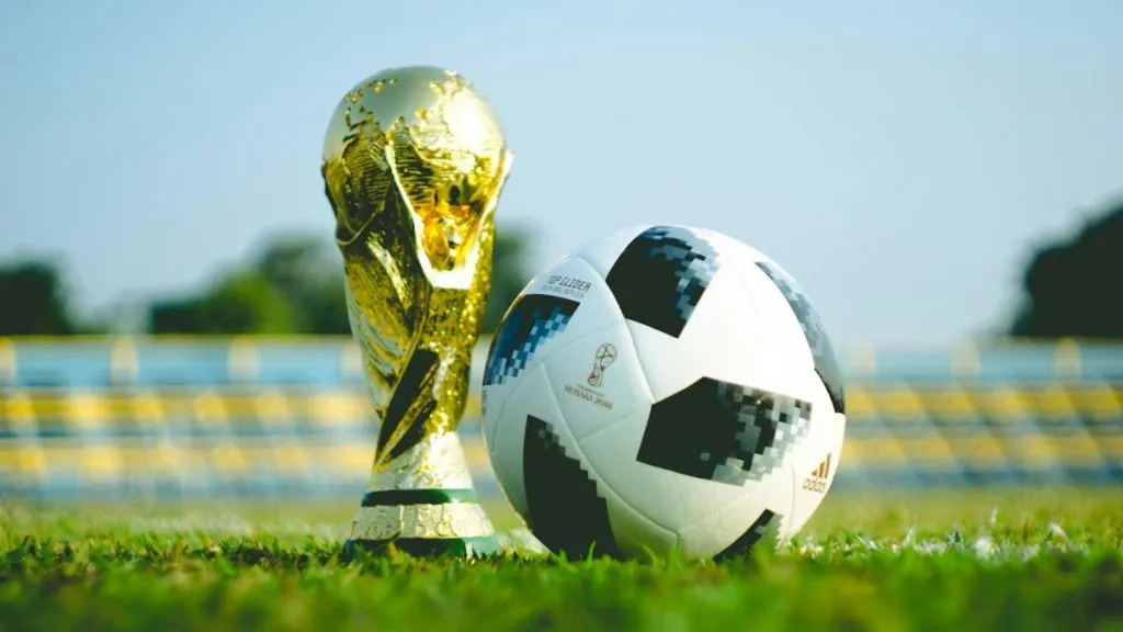 World Cup trophy beside soccer ball